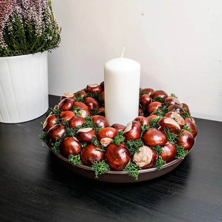 kastanienkerz und weiße große kerze herbstliche deko