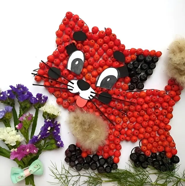 Katze basteln mit Vogelbeeren und mit Cartoon-Augen und Schnurrhaaren gestalten