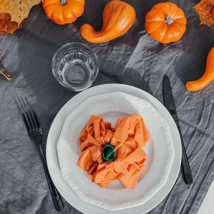 Kürbis aus Servietten falten für Halloween in Orange und mit grünem Papier als Stängel