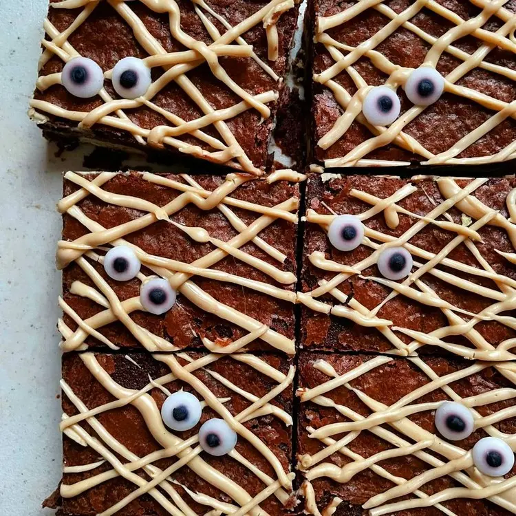 Mumien auf dem Halloween-Blechkuchen gestalten mit Spritzbeutel, Schokolade und Augen