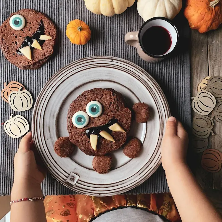 schoko pfannkuchen mit gummiaugen, marmelade und apfel zu halloween dekorieren