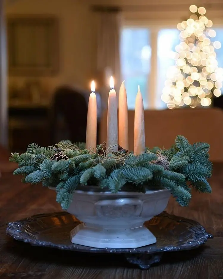 adventskranz in einer suppenterrine mit tammemgrün und tafelkerzen