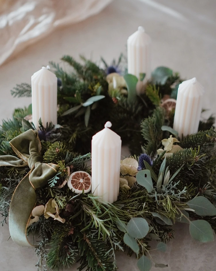 adventskranz mit rillenkerzen und grünem samtband