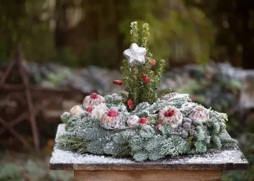 Gartentisch weihnachtlich dekorieren mit einem Kranz und Winterfutter für Vögel