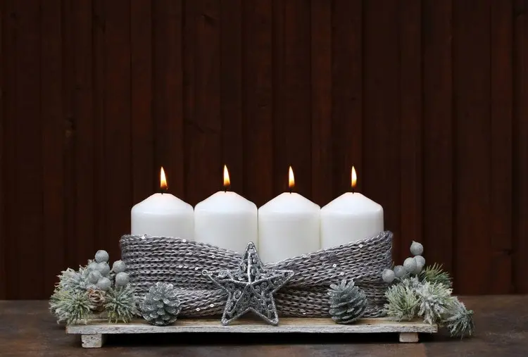 Grauer Adventskranz auf Holzbrett mit Strick als Deko