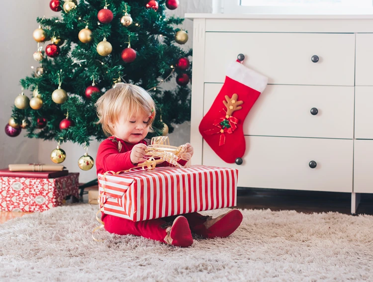 neugieriger kleiner entdecker beim geschenkeauspacken