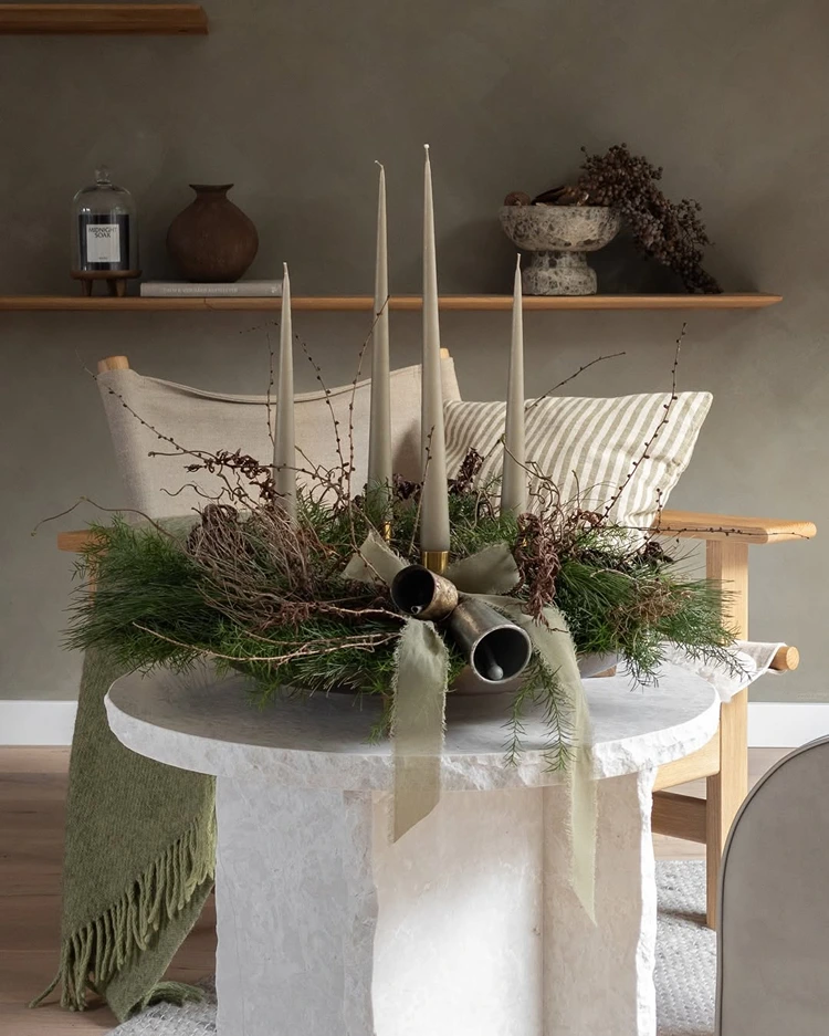 runder adventskranz mit länglichen grauen kerzen