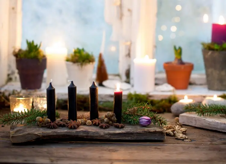 Rustikale DIY-Deko für den Advent mit einem Holzbrett und dunklen Stabkerzen