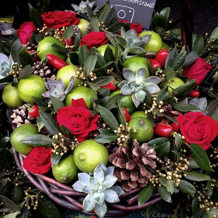 weihnachtsgesteck im korb mit limetten, sukkulenten und rosen