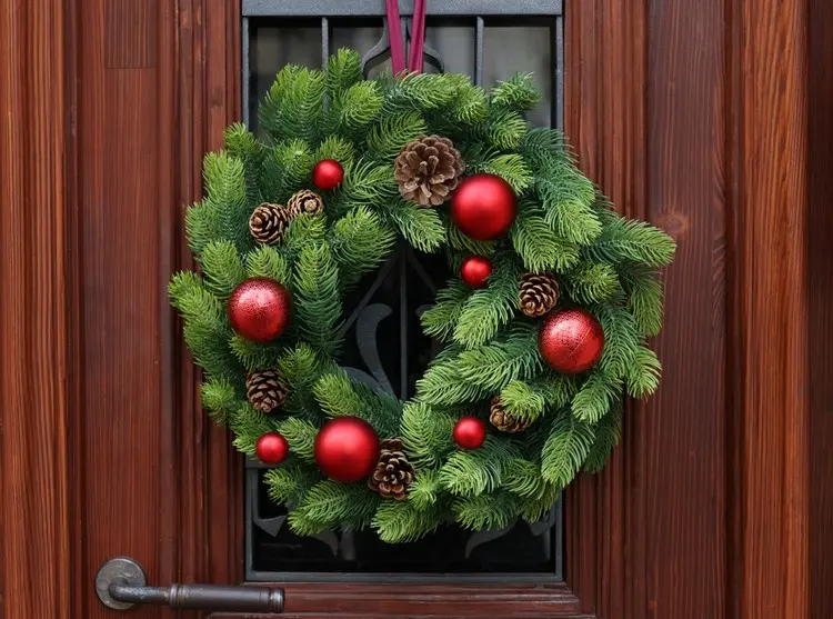 Weihnachtskranz an der Tür befestigen mit einem Band und einem Haken an der Innenseite