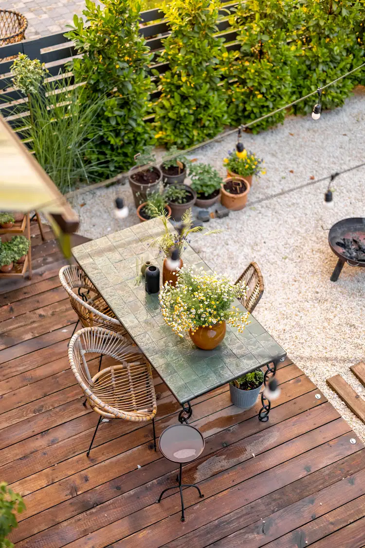 holzterrasse mit esstisch und hecke zum nachbarn