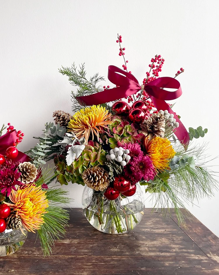 kombination aus frischen winterblumen nadelzweigen tannenzapfen und glänzenden kugeln