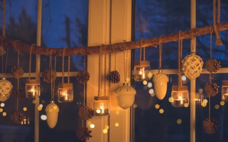 Hängende Fensterdeko für den Winter selber machen an einem Ast mit Windlichtern und Zapfen