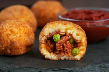 ganze und in scheiben geschnittene sizilianische arancini