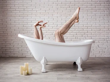 humorvolle szene mit behaarten beinen, die aus einer badewanne ragen