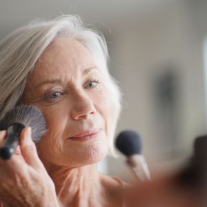 schöne ältere frau, die make up aufbringt