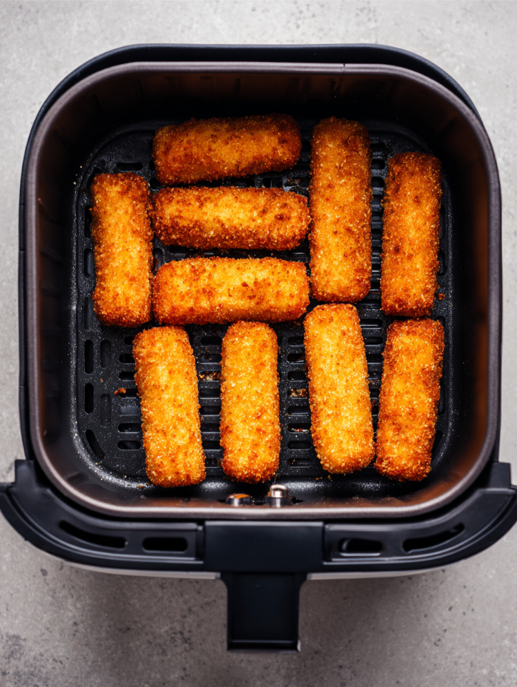 knusprige fischstäbchen im korb einer heißluftfritteuse