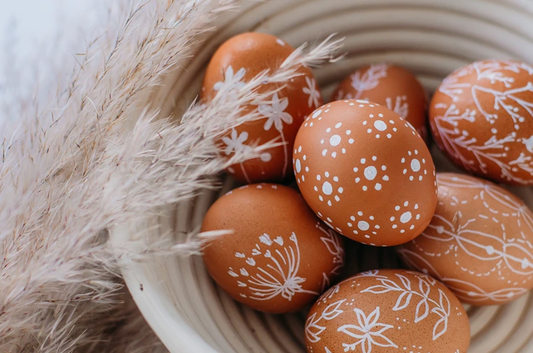 filigrane muster auf braunen ostereiern kombiniert mit trockenem pampasgras