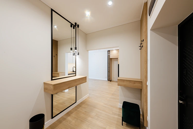 offener flur mit großer spiegelwand, pendelleuchten und holzkonsole