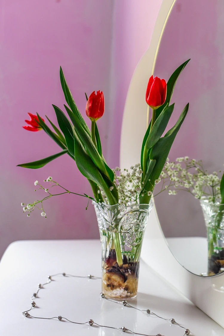 rote tulpen mit schleierkraut kombiniert in einer glasvase