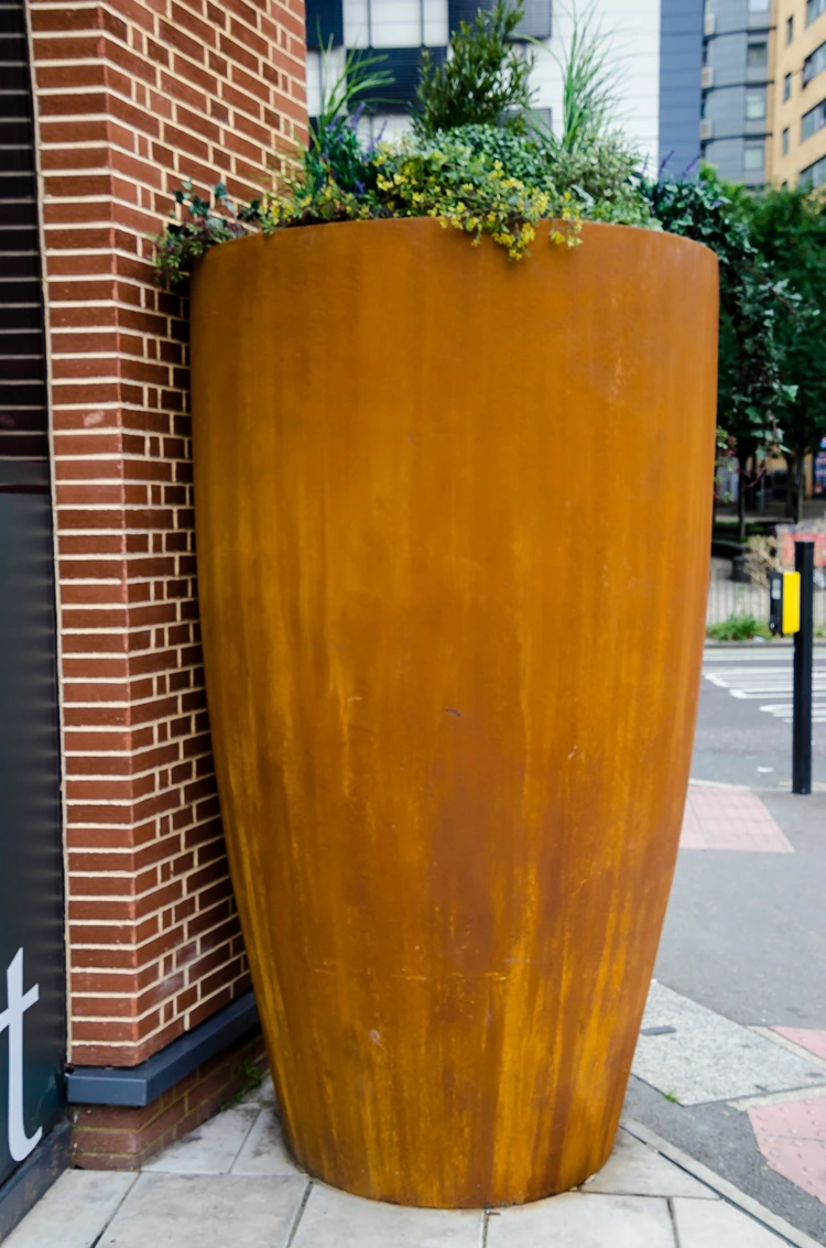abfärbung durch cortenstahlkübel – rostwasser läuft auf gehwegplatten