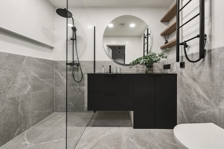 baddesign mit grauen bodenfliesen in steinoptik und weißen wandfliesen