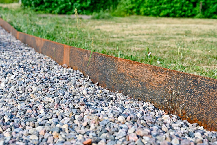 cortenstahl trennt auf elegante weise kiesbeet und rasenfläche