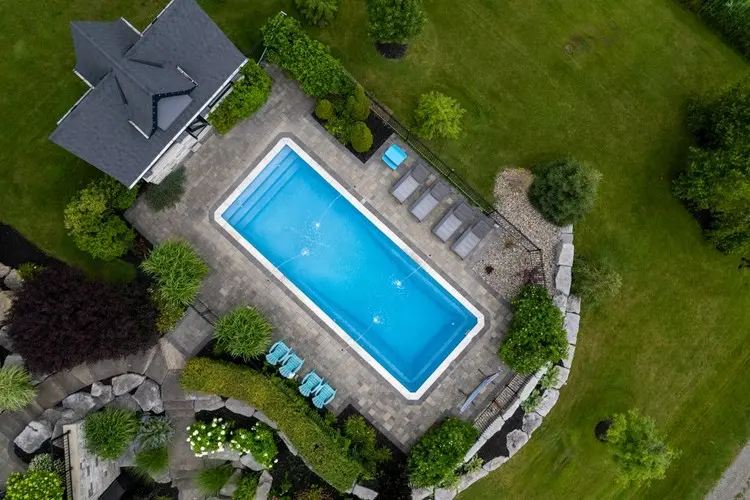 Den Außenpool mit kleinen Beeten aus pflegeleichten Pflanzen gestalten