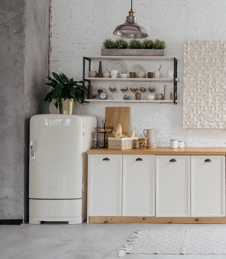 Eleganter Blumentopf in gold mit Pflanze als Deko für eine weiße Landhausküche