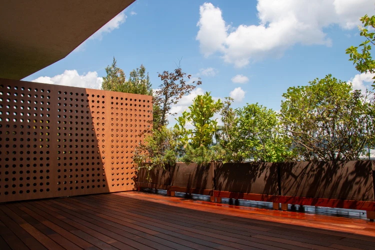 exterieur terrasse mit modernen appartements mit laubholzbeschlag und grünpflanzen für sichtschutz