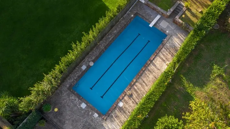 Gestaltung rund um den Pool mit einer Hecke als Sichtschutz