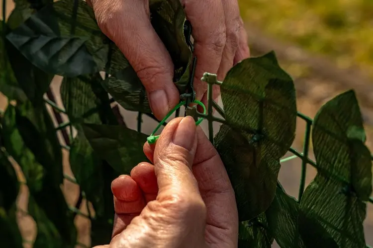 Matten mit Kabelbindern oder speziellen Haken am Zaun befestigen