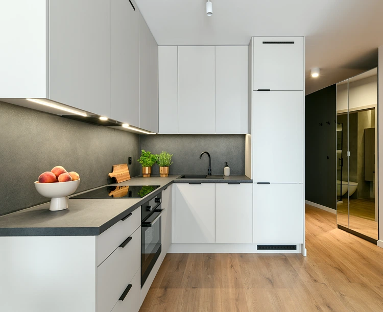 moderne weiße küche mit grauer rückwand und arbeitsplatte