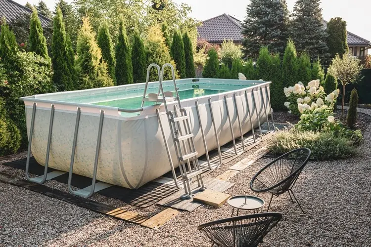 Moderner Kiesgarten mit freistehendem Pool, Gartenstühlen, Hortensien und Heckenpflanzen