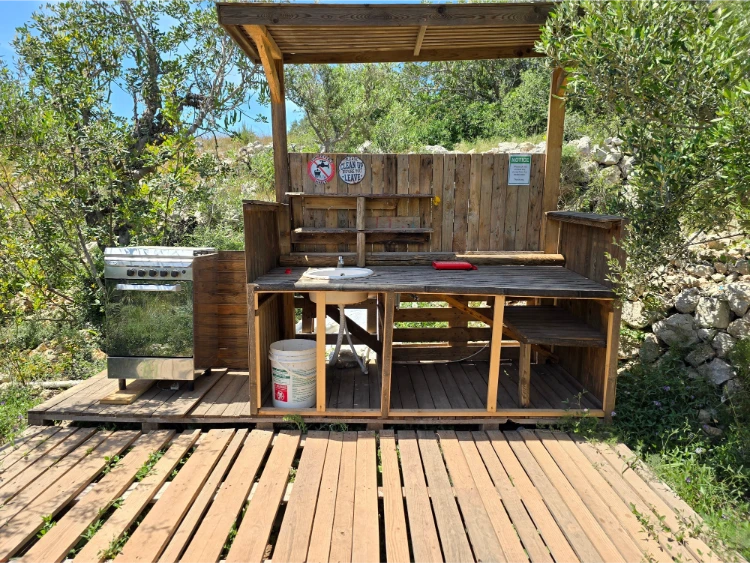 outdoor kücheneinrichtung aus holz mit elektroofen, spüle, regalen und arbeitsplatte