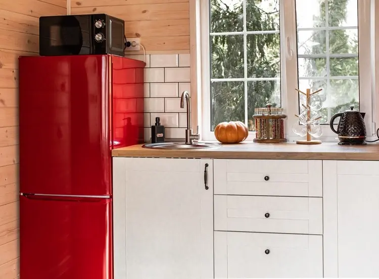 Roter Kühlschrank in einer Landhausküche mit Mikrowelle