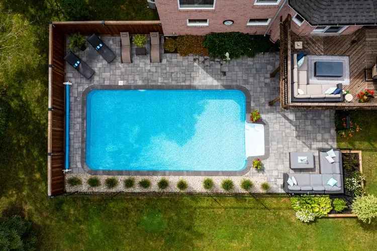 Sichtschutzzaun als Poolumrandung und schmales Beet mit Kies und Sträuchern