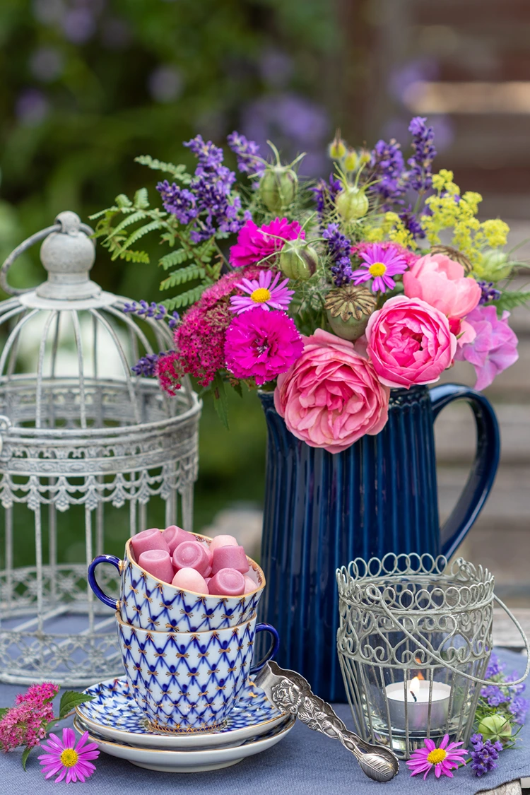 blumenstrauß rosen lavendel in dunkelblauer vase