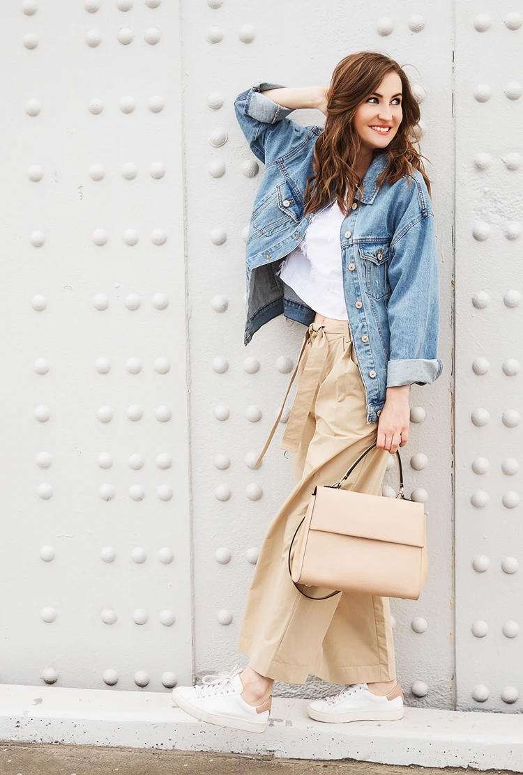 oversized jeansjacke trifft auf weite stoffhose – frischer layering look für milde Übergangstage