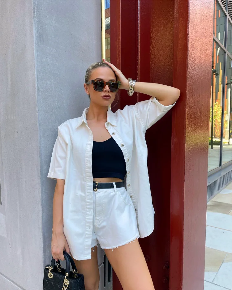 stylisches sommeroutfit mit weißem hemd, weißen shorts und schwarzem top