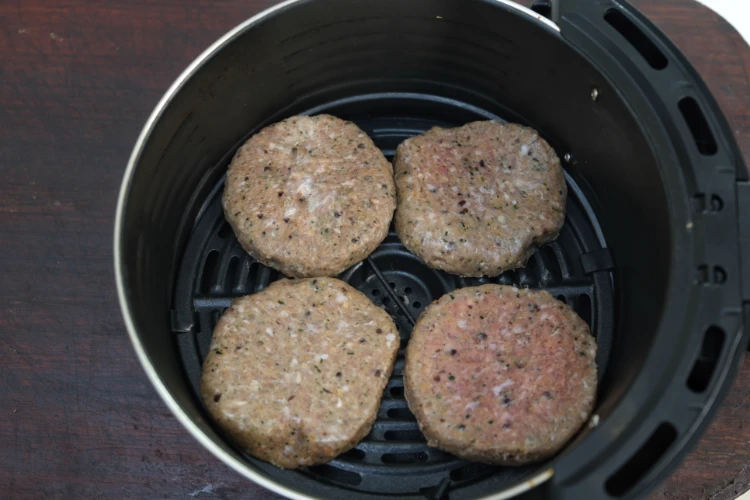 vier rohe burger patties im airfryer