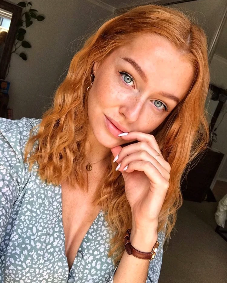 frau mit blauen augen und apricot copper lockigem haar