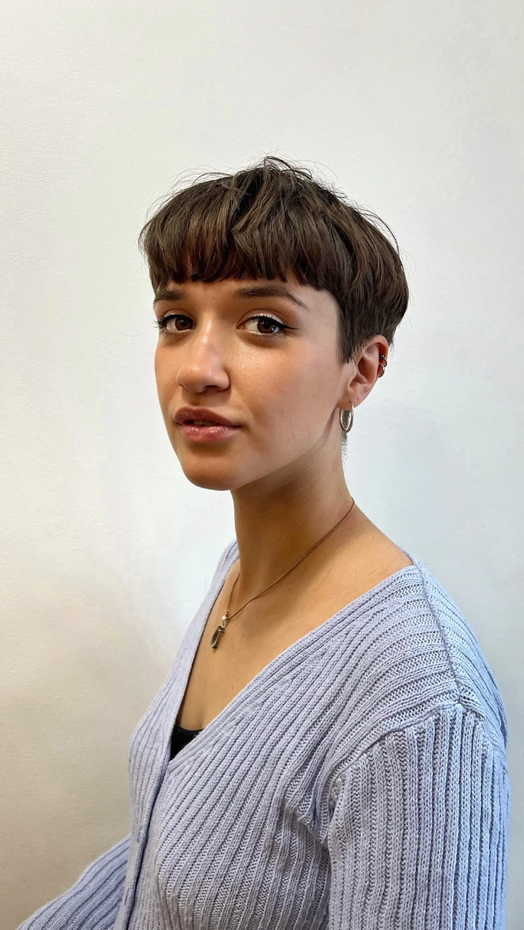 frau mit braunem haar und glattem bowl pixie cut