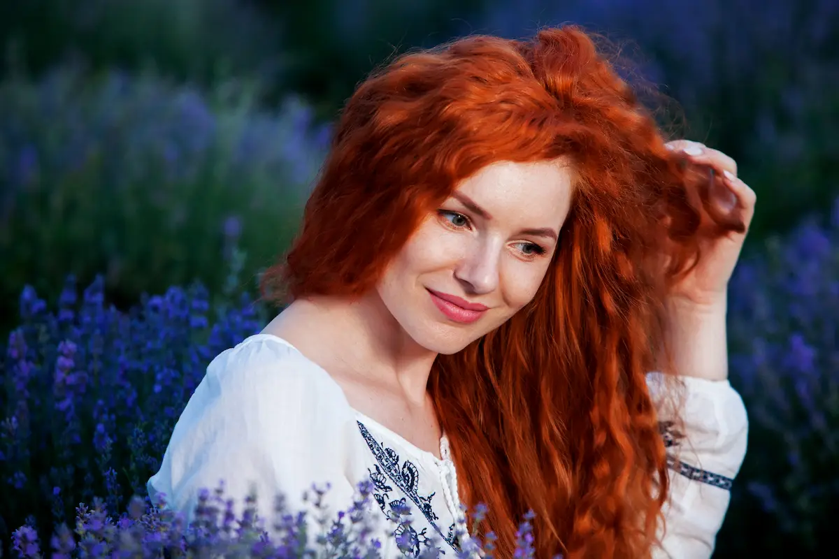 frau mit schönen lockigen haaren in einem roten kupferton