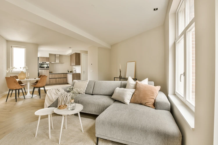 großzügiges wohnzimmer mit grauem ecksofa und braunen akzenten