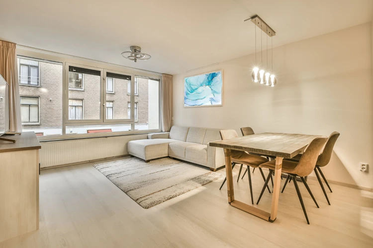 helles wohn und esszimmer mit minimalistischer einrichtung und blauen kunstakzenten