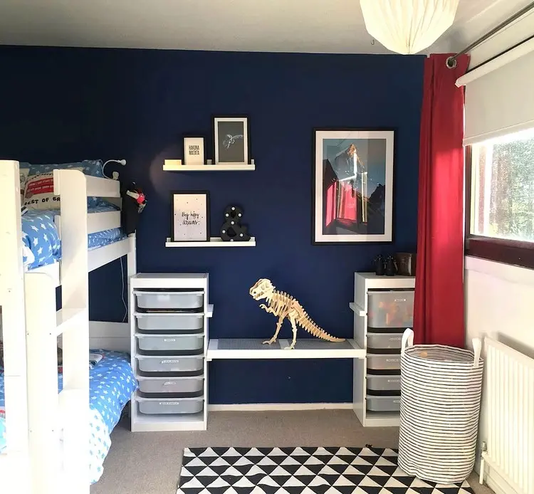 Kleiner Schreibtisch mit weißen Regalen und flachen Boxen