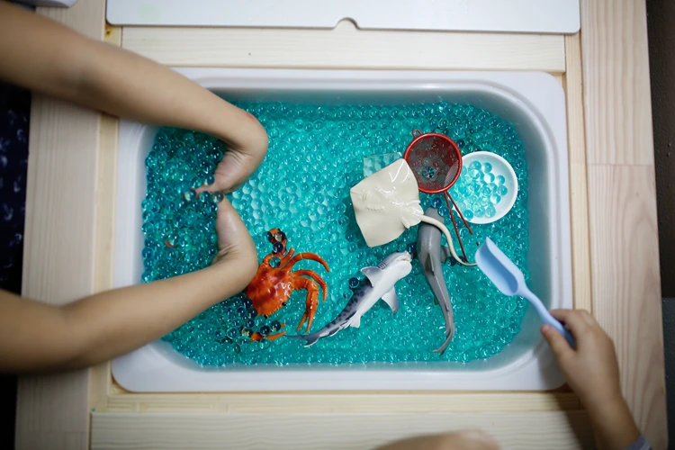 meer aus blauen wasserperlen mit spielzeugen meeresbewohner