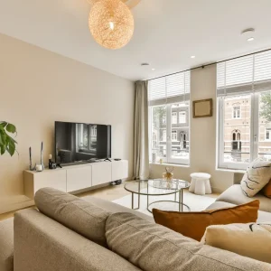 modernes beiges wohnzimmer mit gemütlicher sitzecke und großen fenstern