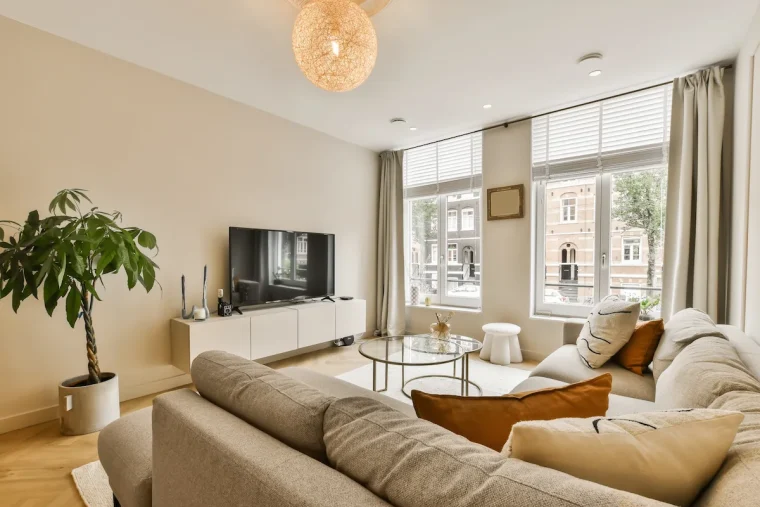 modernes beiges wohnzimmer mit gemütlicher sitzecke und großen fenstern